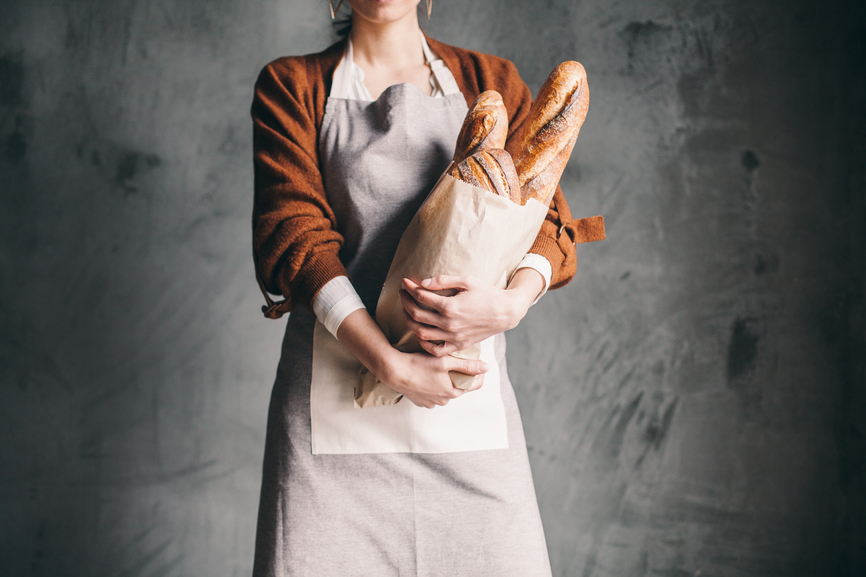 Woman Holding a Bag With Bread